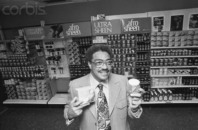 11 Jan 1976, Chicago, Illinois, USA --- Chicago: George E. Johnson a black black entrepreneur with a high school education who parlayed a $250 investment into a company that grossed $39 million in sales, is seen in his office holding a few of the products made by Johnson Products Co., Inc. The firm is now the largest black manufacturing company in the world, with over 400 employees. --- Image by © Bettmann/CORBIS